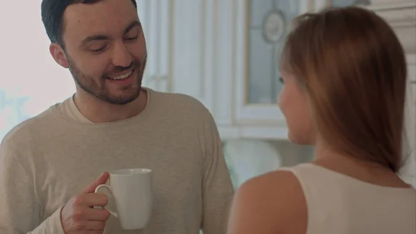 Feliz pareja joven cocinando juntos en la cocina en casa y besándose — Foto de Stock