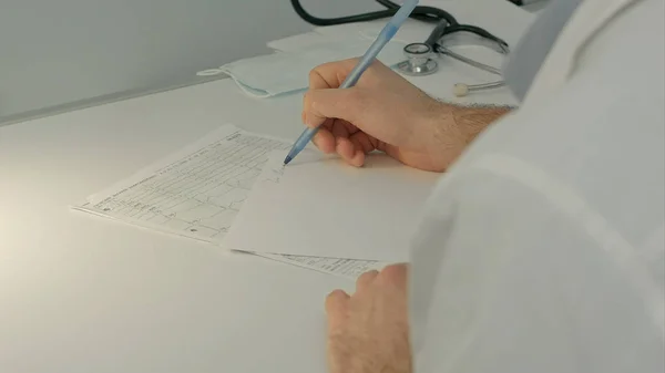 Doctor sentado en el escritorio con papel y trabajando — Foto de Stock