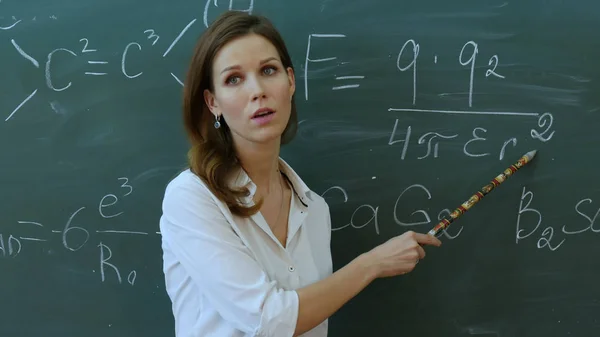 Lärare i klassrummet på blackboard bakgrund förklara något i phisics. — Stockfoto