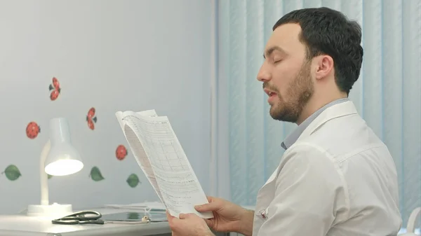 Лікар читає картку пацієнта в лікарні . — стокове фото