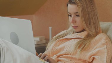 Bir dizüstü bilgisayar ile bir hastane yatağında yatan bir hasta