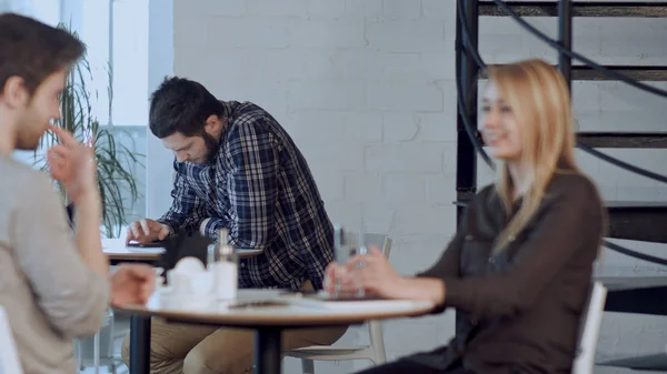 Jovem preocupado usando tablet no café, sentado sozinho — Fotografia de Stock