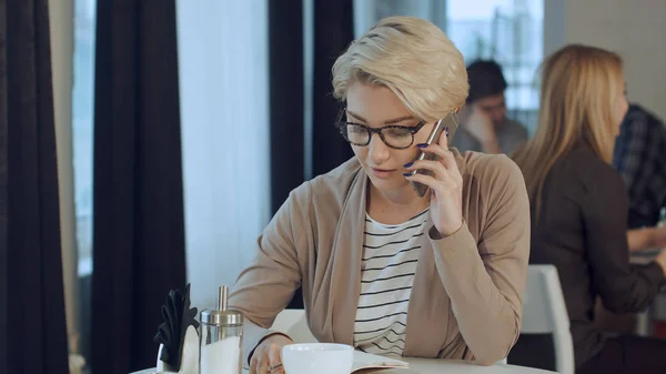Счастливая деловая женщина разговаривает по телефону в кофейне — стоковое фото