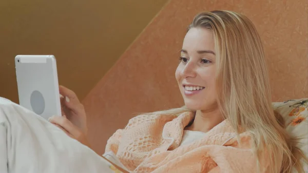 Mulher sorrindo usando tablet digital enquanto deitado na cama do hospital — Fotografia de Stock