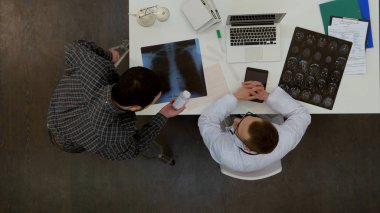 Doktor tarafından reçete ilaçları kontrol koltuk değneği ile genç adam