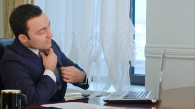 Genç işadamı office ve dizüstü bilgisayarınızda çalışmaya başlayın kollarında germe