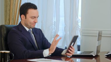 Ofiste masanın üstüne belgelerle tablet toplantı yakışıklı işadamı vardır