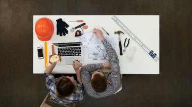 Mimar planları sırasında kadın meslektaşım dizüstü bilgisayarda rapor yazarak çalışma