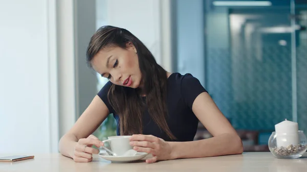 Jovem sonhadora segurando uma xícara de café e cantando no café — Fotografia de Stock