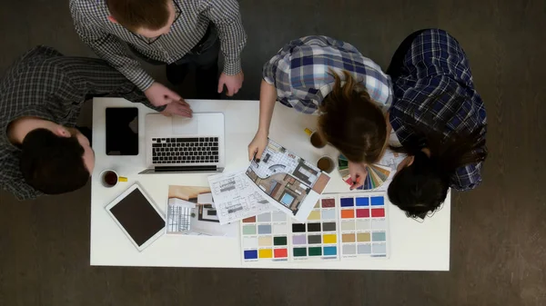 Diseñadores hablando con el cliente por teléfono mientras seleccionan muestras de color — Foto de Stock