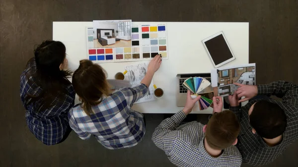 Progettisti che lavorano in ufficio con layout e tavolozza dei colori rispondendo alle telefonate e sgomberando la scrivania — Foto Stock