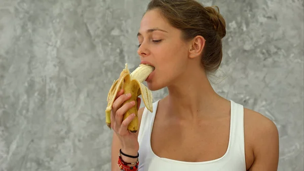 Привлекательная женщина ест банан — стоковое фото