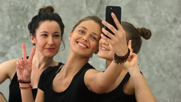 Tres mujeres jóvenes haciendo selfie después del entrenamiento en la clase de yoga — Foto de Stock