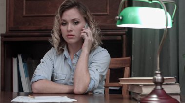 Kötü haber ile bir telefon görüşmesi cevap ve kafasını eline alarak endişeli kadın