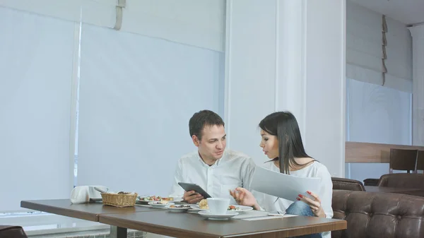 Két kollégák munka közben eszik ebédre egy kávézóban megvitatása — Stock Fotó