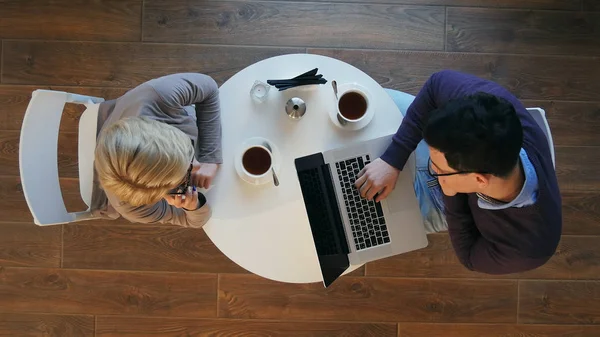Partnerek élvezi a munkát a világos, modern kávézó, nő, miután egy telefon hív, ember dolgozik-ra laptop — Stock Fotó