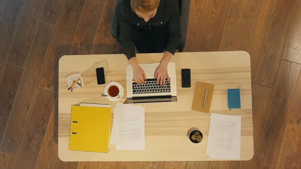 Счастливый случайный предприниматель, работающий в режиме онлайн, печатая с ноутбуком в офисе с окном на заднем плане — стоковое фото
