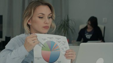 Dizüstü bilgisayar üzerinden arkadaşlarınıza pasta grafiği açıklayan kadın ofis