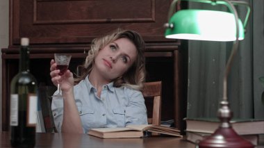 Bir kitap okuma ve bir kadeh kırmızı şarap tadını genç kadın