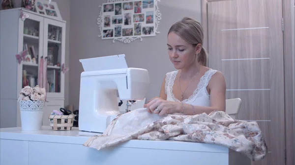 Young beautiful woman using electric sewing machine