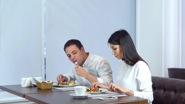 Молодая пара наслаждается обедом в кафе, когда официант подает больше еды — стоковое фото