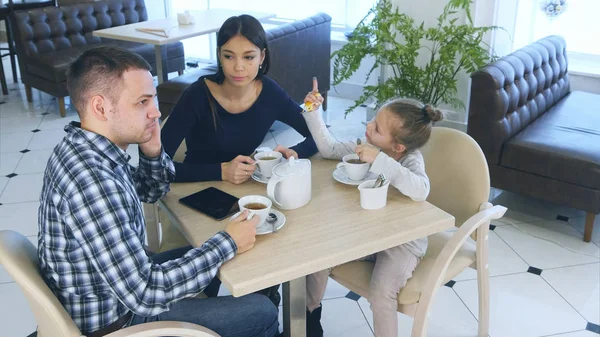 Pai falando ao telefone enquanto se senta com sua esposa e filha no café ou restaurante. Mãe olhando com raiva dele . — Fotografia de Stock