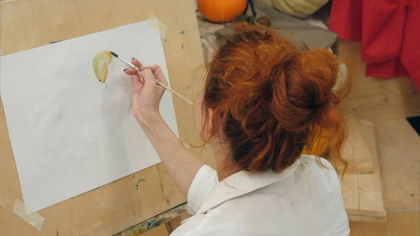 Jovem artista feminina pintura aquarela imagem no estúdio — Fotografia de Stock