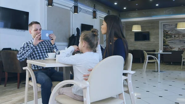 Famille européenne sympathique prenant des photos dans un café pendant leur dîner . — Photo