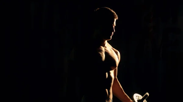 Kulturysta pozowanie. potęga przystojny facet lekkoatletycznego mężczyzna. muskularne ciało fitness na czarnym tle — Zdjęcie stockowe