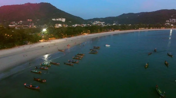 Muchos barcos de pesca están en el amarradero cerca de la playa por la noche — Foto de Stock