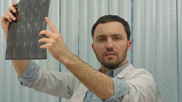 Mužský lékař při pohledu s humorným šokem na rentgen — Stock fotografie