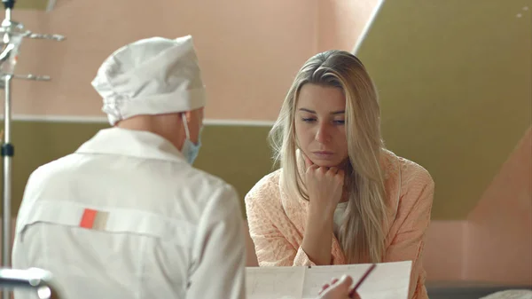 Молодая женщина-врач с пациенткой разговаривает в больнице — стоковое фото