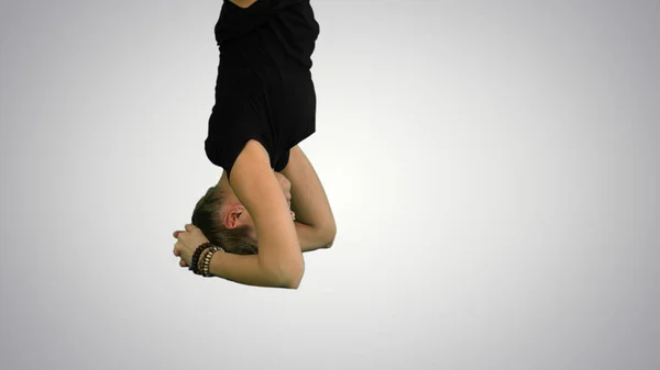 Menina fazendo ioga asana upavishtha konasana shirshasana, ligado Ângulo Pose na cabeça em pé no fundo branco — Fotografia de Stock