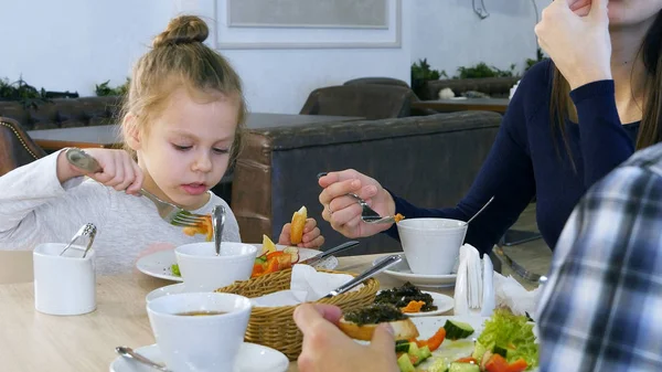 Aile restaurant, sağlıklı yemek yerim. Küçük kızı beyaz ekmek ile sebze salata yemek. — Stok fotoğraf