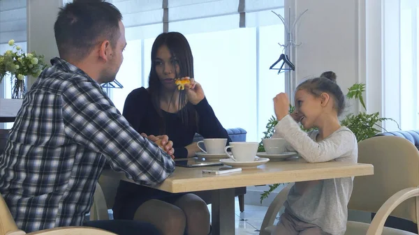 Padre e hija esperando a su madre en el café. Mujer hablando con una sonrisa encantadora . —  Fotos de Stock