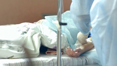 Hemşire hastane odasında hasta bir kol bir damlalık koymak