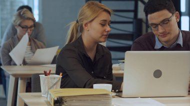 Dizüstü bilgisayarda modern ofiste çalışan iş ortakları