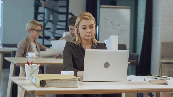 Jeune femme travaillant sur ordinateur portable dans le bureau — Photo