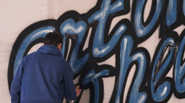 Genç kentsel ressamın grafiti harf duvardaki çizim