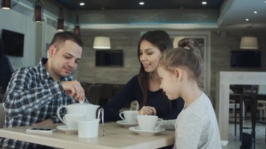 Genç aile kafede çay ve şeker getiren garson.