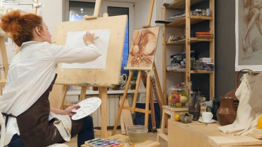 Genç kadın sanatçı onun atölyesinde palet resim kullanma