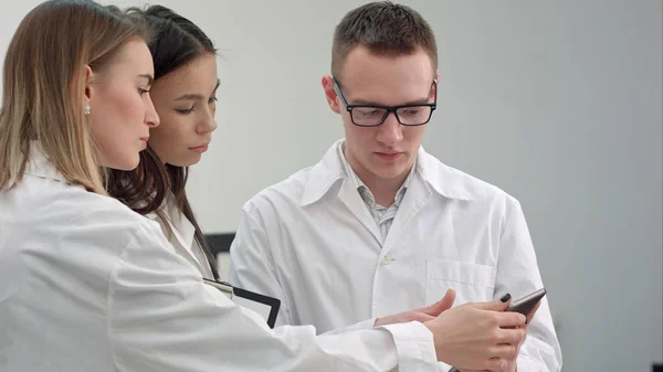 Médecin féminin montrant quelque chose sur comprimé à son équipe médicale — Photo