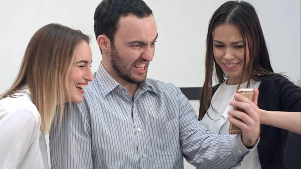 Tres compañeros de trabajo alegres tomando selfies divertidos por teléfono — Foto de Stock