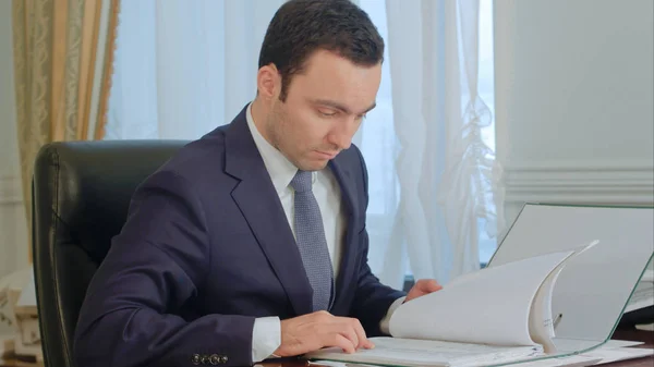 Empresario leyendo documentos y hablando por teléfono fijo — Foto de Stock