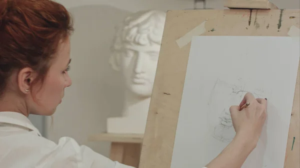 Sanat stüdyosu bulunan konsantre kadın sanatçı boya sıva büstü