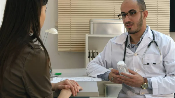 Bayan hasta ilaç reçete ve yan etkileri açıklayan erkek doktor