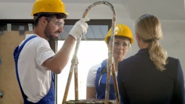 Kadın mimar ve inşaat ekibi inşaat alanına, Plan tartışıyor