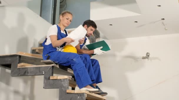 Grupo de trabajadores de la construcción viendo algunos detalles en un plano — Vídeos de Stock