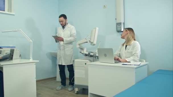 Medical doctors busy working in the office using laptops and tablet — Stock Video