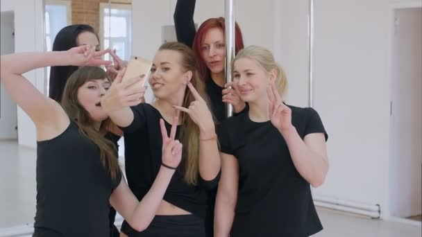 Grupo de hermosas mujeres jóvenes tomando una selfie con smartphone durante una clase de pole dance — Vídeo de stock